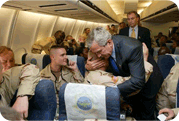 photo of president gw bush hugging service men and women on plane